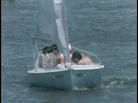 Small sailboat carrying passengers on the water.