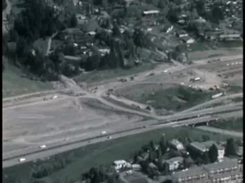 Aerial view of a highway interchange and surrounding buildings.