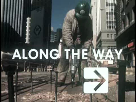 Worker using jackhammer on city street