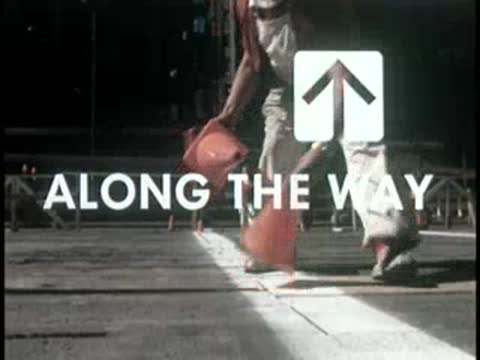 Worker placing traffic cones on street crosswalk