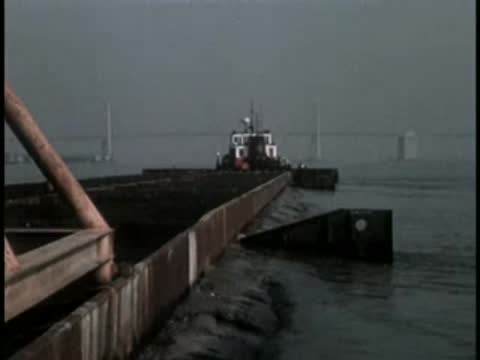 View from a barge moving across the bay towards a bridge.