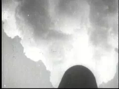Thick billowing smoke rising against a bright sky from an industrial source.