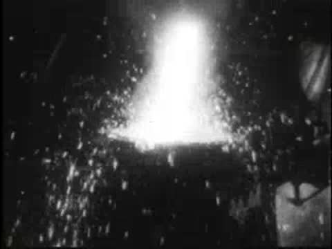 Bright sparks flying upwards from a molten metal pouring process in a foundry.