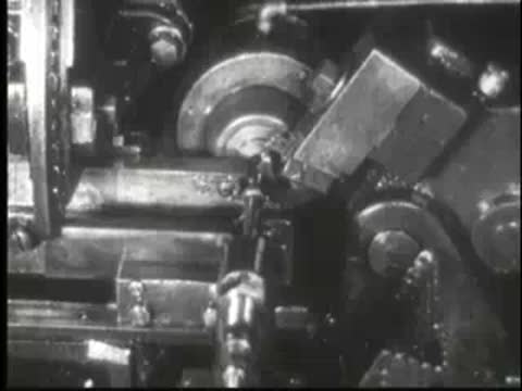 Rotating metal component being shaped by a cutting tool in a machine.