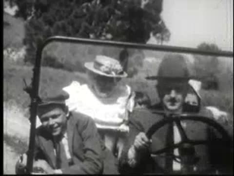 passengers looking out from inside a moving vintage car