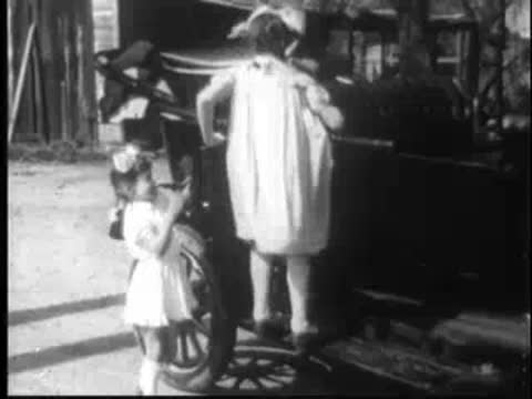 children climbing into a vintage car parked outdoors