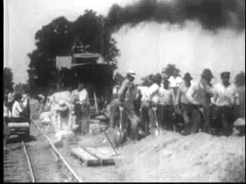 Crew of men with shovels working on road construction site.