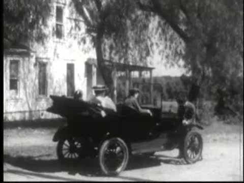 vintage cars driving along a rural dirt road