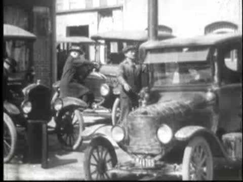 Old trucks and cars parked in front of buildings.
