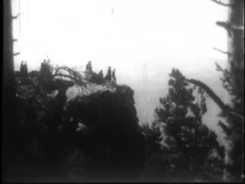 People standing on a rocky outcrop overlooking a landscape.