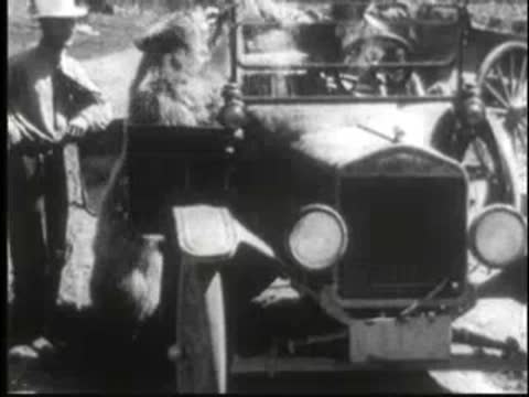 Close-up of a vintage car with people standing next to it.
