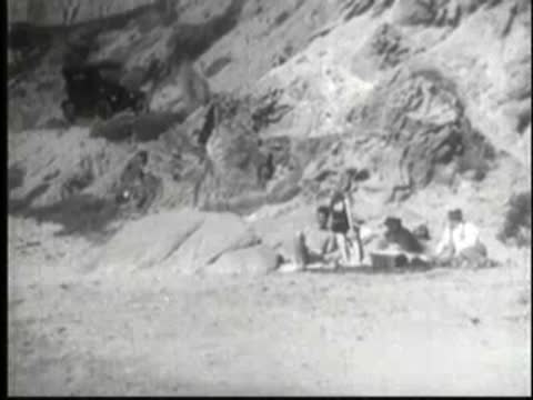 Group of people sitting and relaxing on a sandy beach.