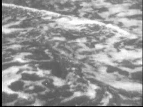 Close-up view of ocean waves crashing onto the sandy shore.