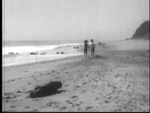 People walking along a wide sandy beach toward the ocean.