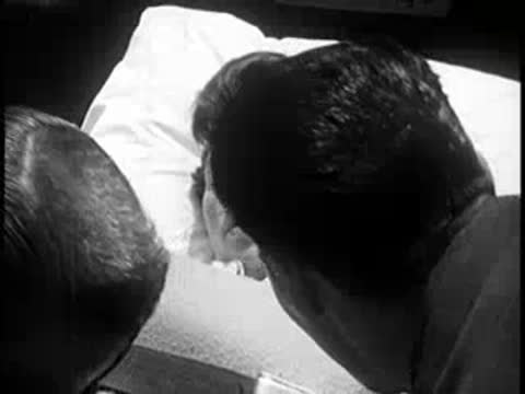 Patient in a hospital bed being tended to.