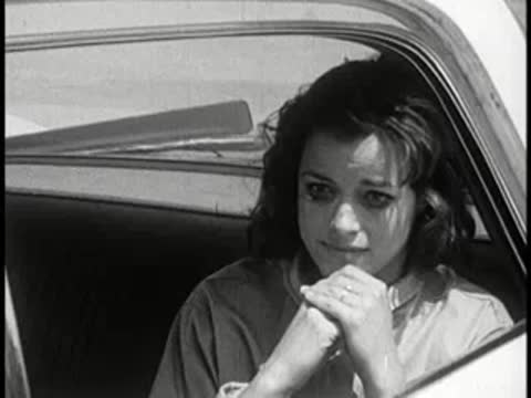 Distressed young woman sitting inside a police car.
