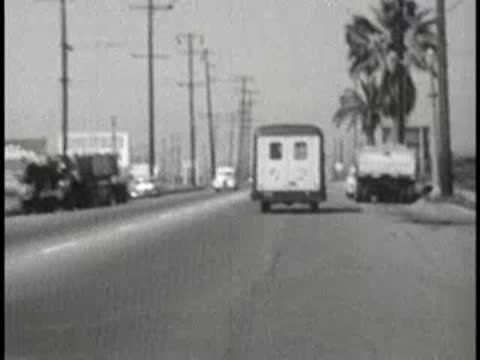 daytime driving view following delivery van on suburban street, 1960s