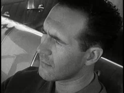 driver looking around inside car during daytime, 1960s