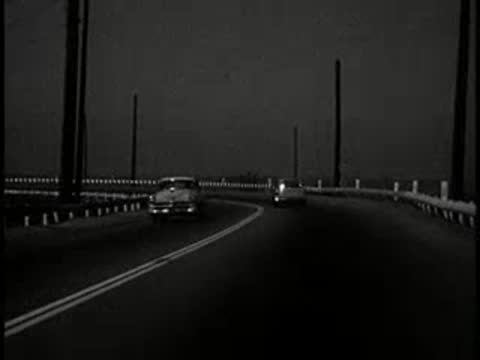 driving view on dark curved road at dusk, 1960s