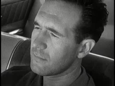 driver looking around inside car and exterior car driving away, 1960s