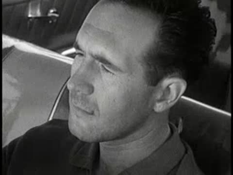 driver looking around inside car and view of beer bottle, 1960s