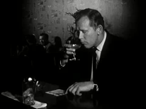man sitting at bar drinking cocktail at night, 1960s