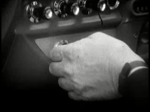 Close-up of a hand inserting key into car ignition and turning.