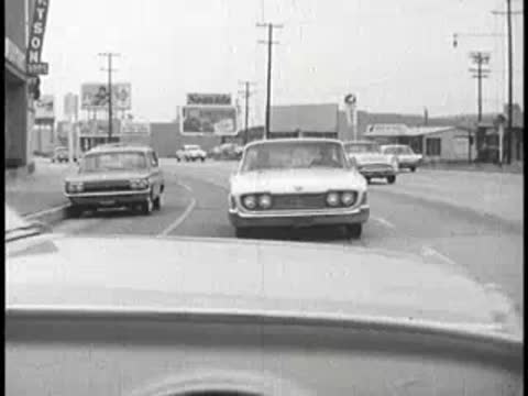 Driving on a street past other cars, POV shot.
