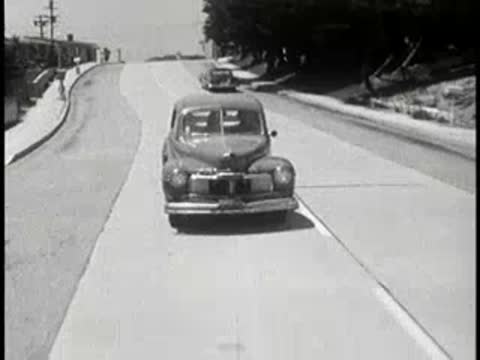 Vintage car driving down a residential street from driver POV.
