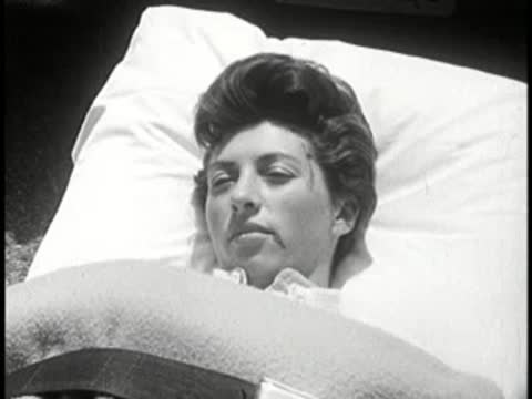 Person lying on a hospital bed with a bandage.