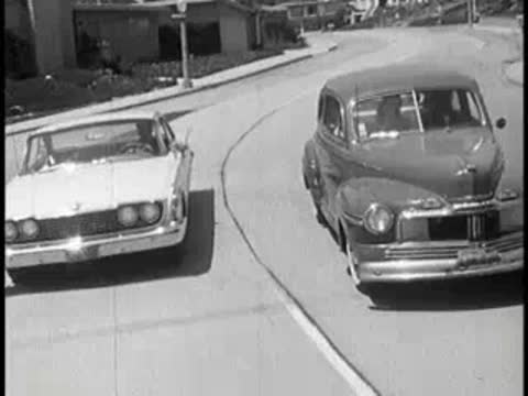 Two cars driving past each other on a suburban street.