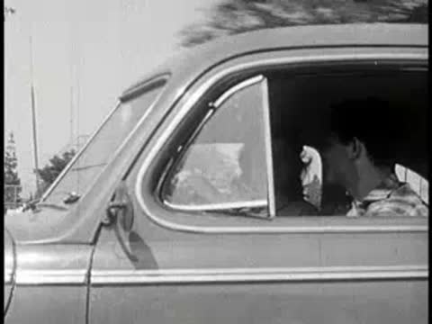 Side view of a couple sitting and talking inside a moving car.