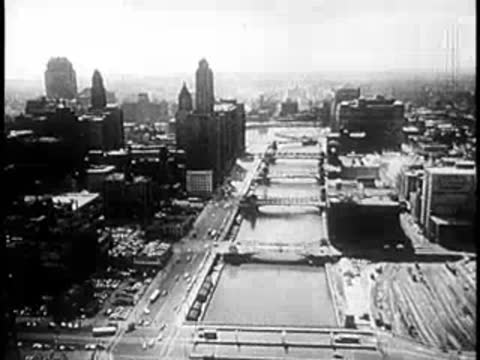 Aerial view of a city landscape with a central river and high-rises.