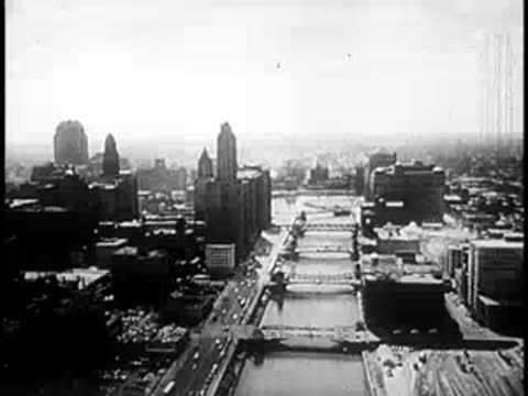 Aerial view fading to a bright white sky over a city skyline.