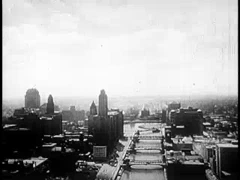Faded aerial shot of a city skyline transitioning into a bright white screen.