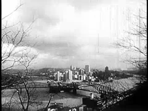 Cityscape with a bridge crossing a river surrounded by hills