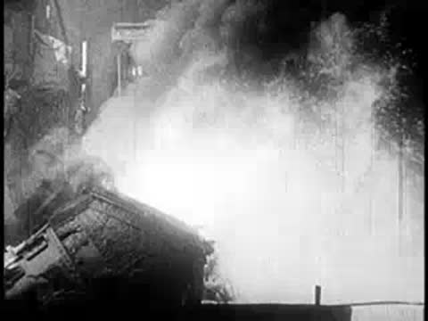 Molten metal container pouring material with sparks and smoke.