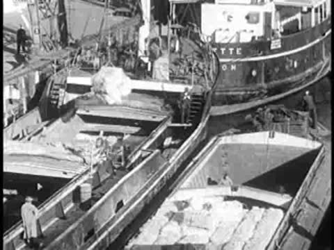 Aerial view of barges and boats on a waterway with cargo being loaded