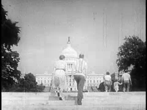 People walking up steps toward the United States Capitol building