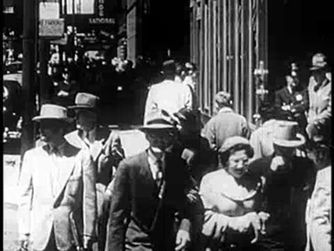 Crowd of people walking along a bustling city street