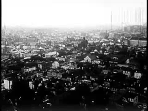 Wide aerial panorama overlooking a sprawling city skyline and neighborhoods