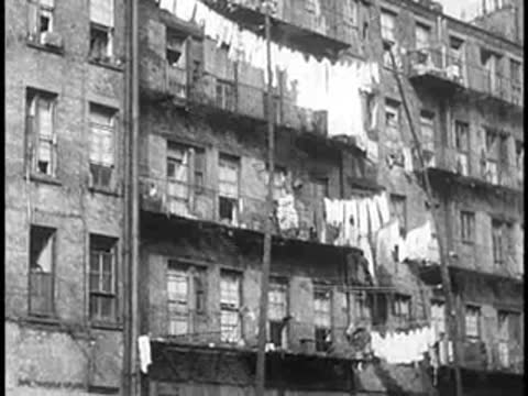 Multi-story apartment building with laundry hanging from exterior lines between windows