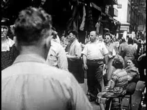 Crowd of people walking on a busy city street, vintage attire and hats