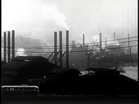 Industrial riverside with smokestacks and factories emitting smoke, mid-century manufacturing
