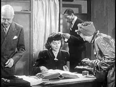 Office workers reviewing large record books and documents at a desk, professional setting