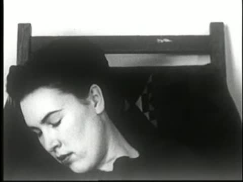 Woman's head remaining slumped to the side in deep sleep, static medium shot.