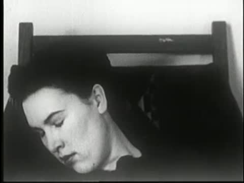 Woman in deep sleep with head tilted, static medium shot.