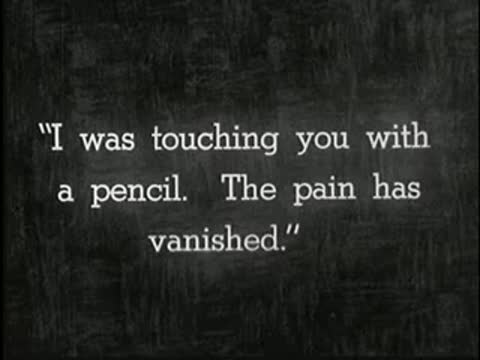 Intertitle on dark background reading: I was touching you with a pencil. The pain has vanished.