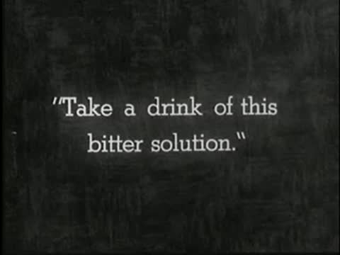 Intertitle on dark background reading: Take a drink of this bitter solution.