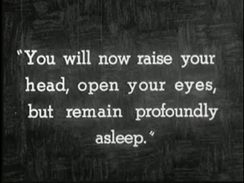 Intertitle on dark background reading: You will now raise your head, open your eyes, but remain profoundly asleep.